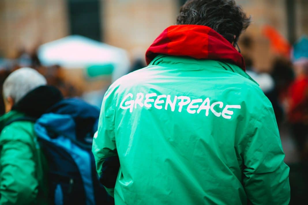 Aktywista Greenpeace w kurtce z napisem Greenpeace