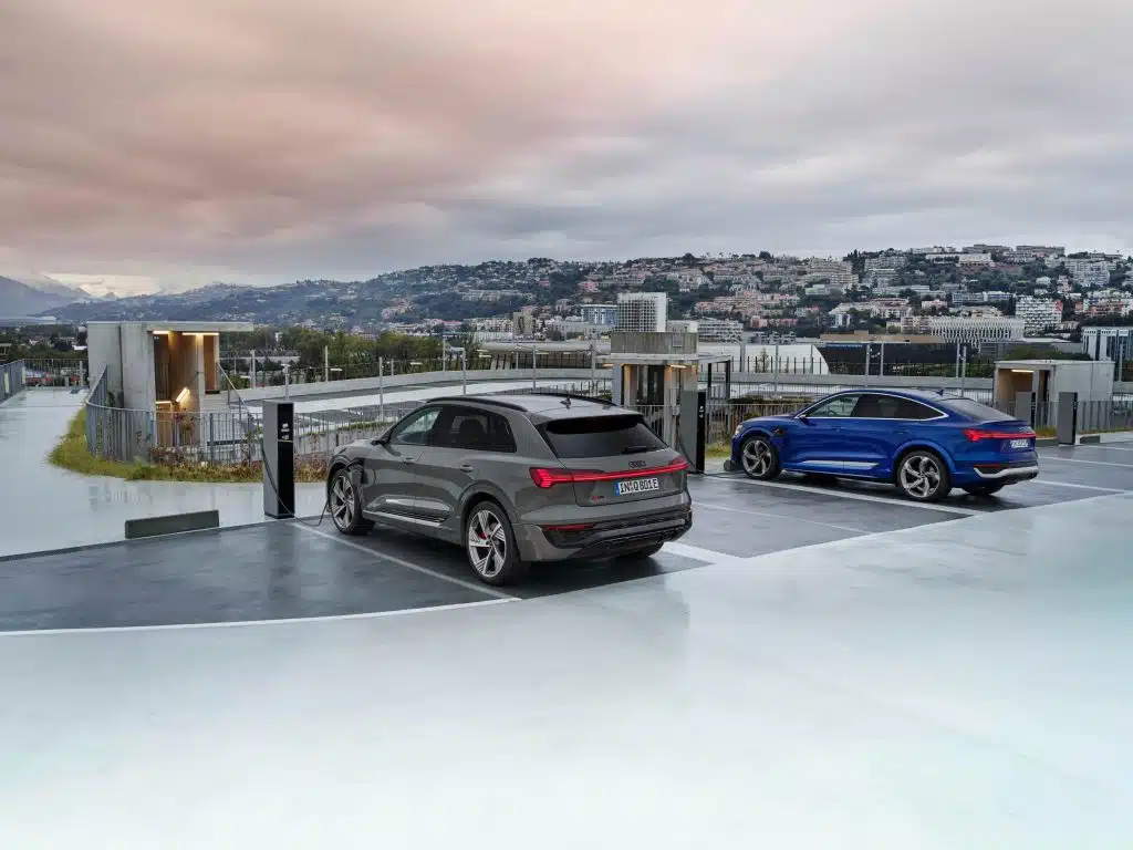 Samochód Audi e-tron ładujący się na tle miasta